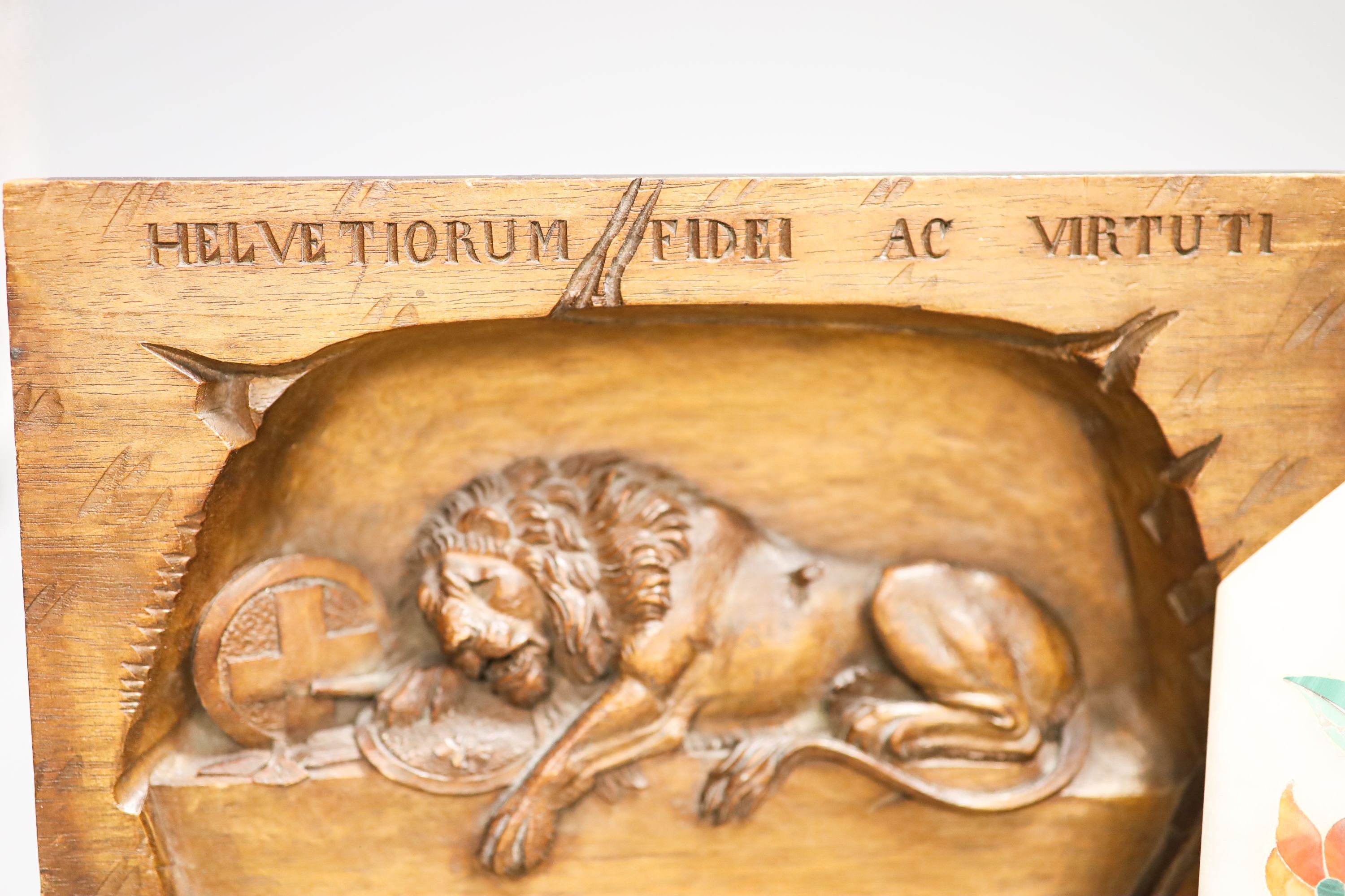 A walnut Lion of Lucerne plaque and carving and an Indian hardstone plaque